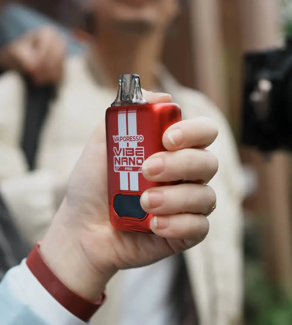 A man vaping outdoors in daylight with the VAPORESSO VIBE, highlighting its 4.5ml pod capacity for an all-day vaping experience on a single fill.